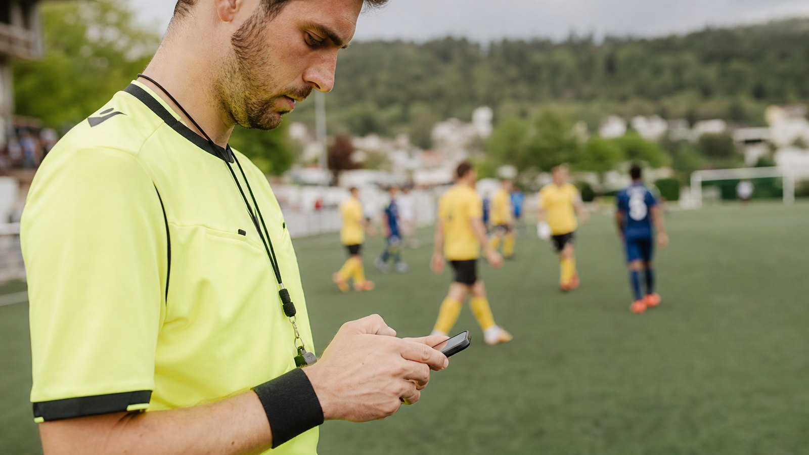Saisie d'un score sur un téléphone au bord d'un terrain